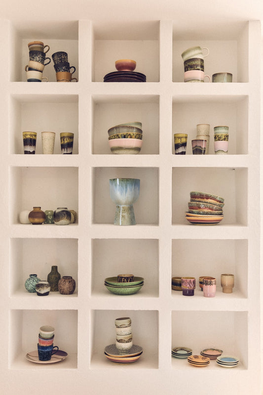 Shelving unit with various ceramic items including cups, bowls, and vases.