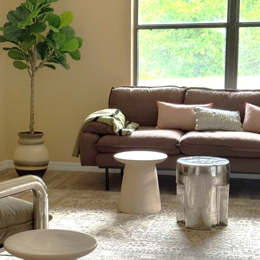 Living room with brown sofa, armchair, and decorative items.