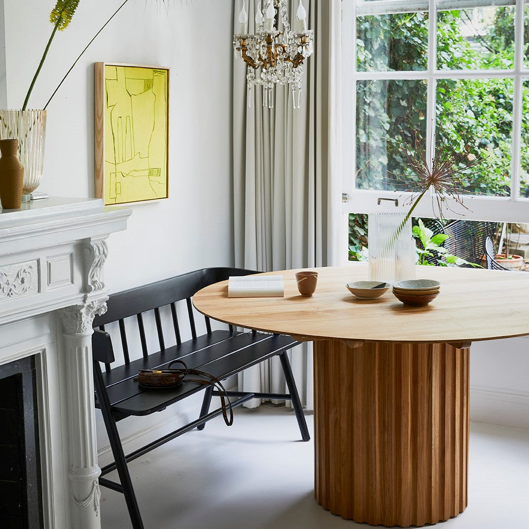 Round teak wooden dining table and black wooden farmhouse bench