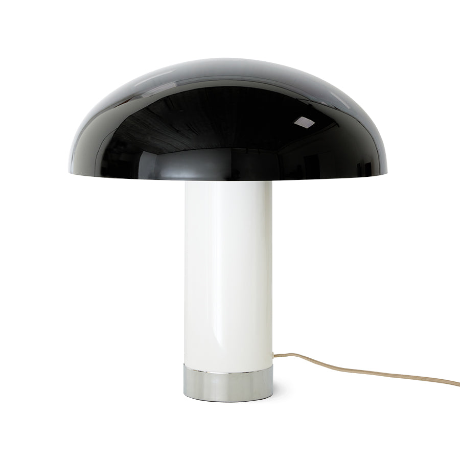 Table lamp with black dome shade and white cylindrical base on a white background