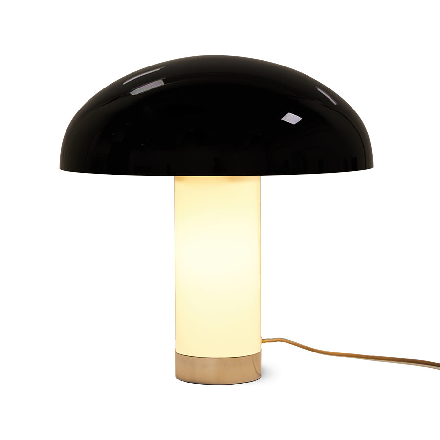 Table lamp with black dome shade and white base on a white background