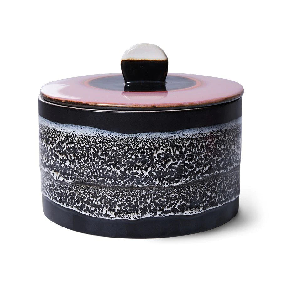Ceramic jar with a speckled design on a white background